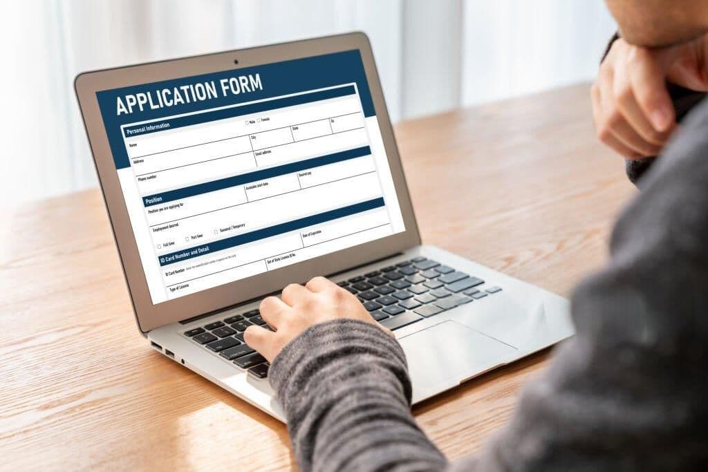 Person filling out a digital application form on a laptop