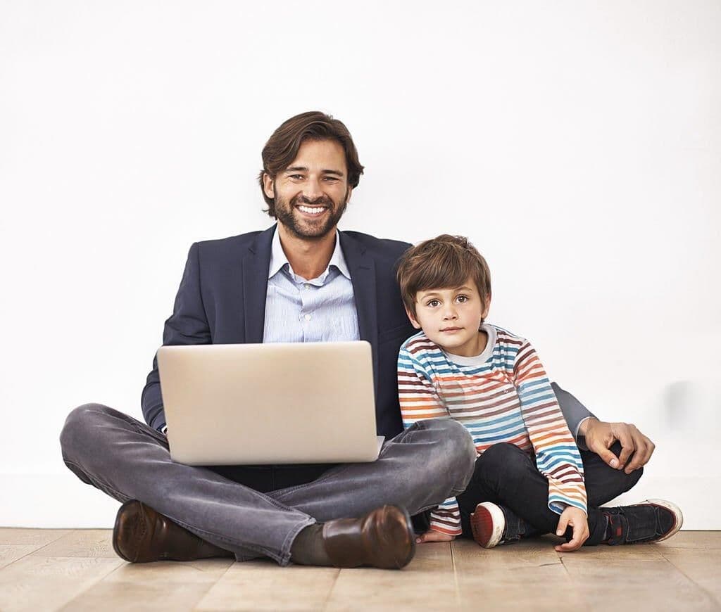 Parent and child sitting together with a laptop, representing a parent and guardian portal