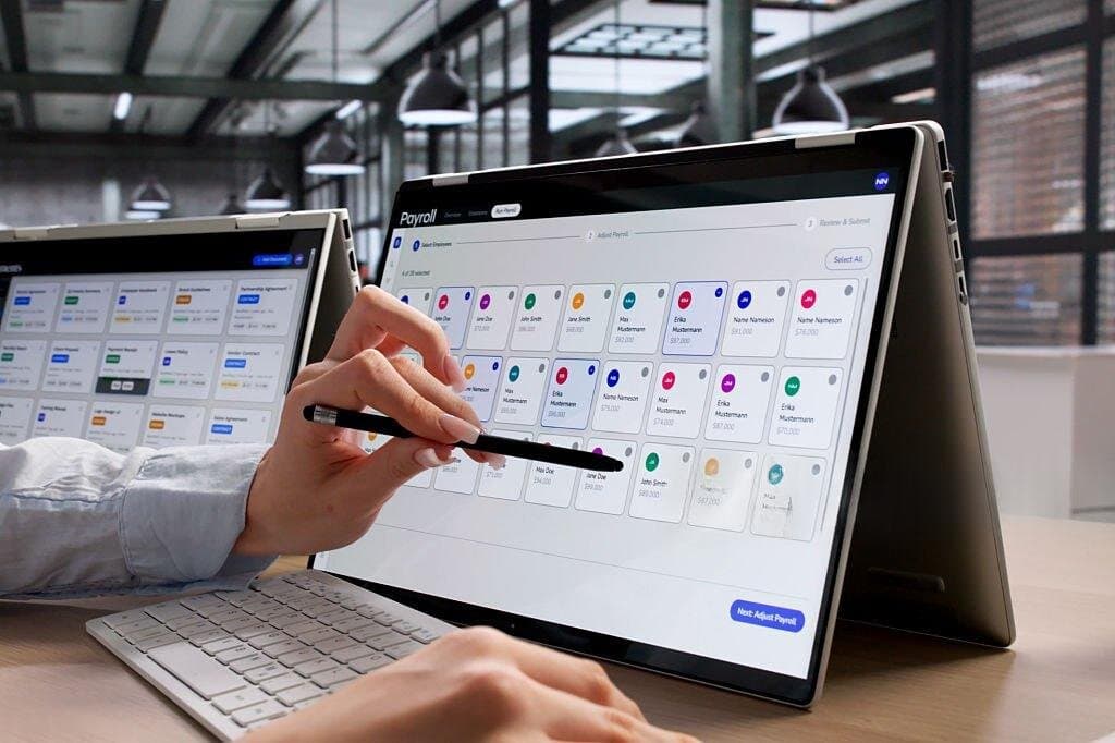 Someone reviewing a payroll dashboard with employee records on a tablet